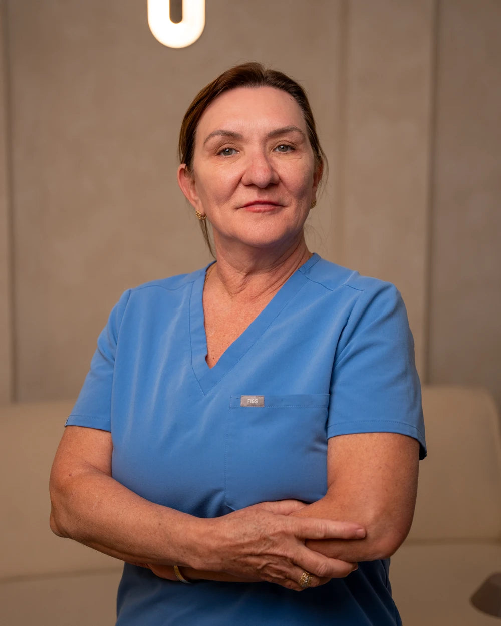 Lucy, founder of Lucy’s Renewals, in her blue healthcare scrubs
