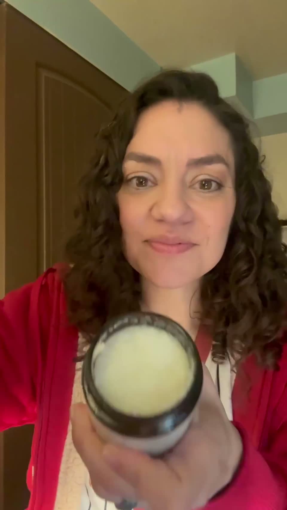 A woman holding the open balm jar