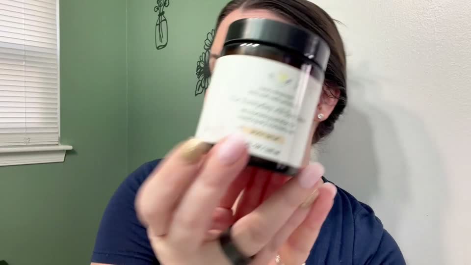 A creator showing the balm jar